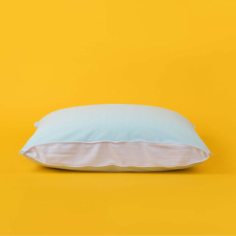 The zipper opened fully on the Slumber Cloud Adjustable UltraCool Pillow on a cream background