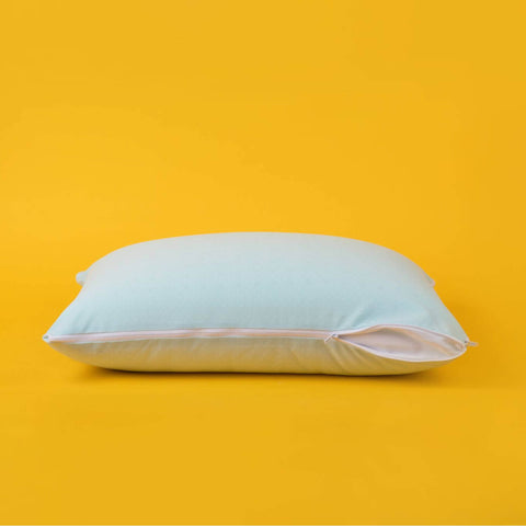 The zipper opened partially on the Slumber Cloud Adjustable UltraCool Pillow on a cream background