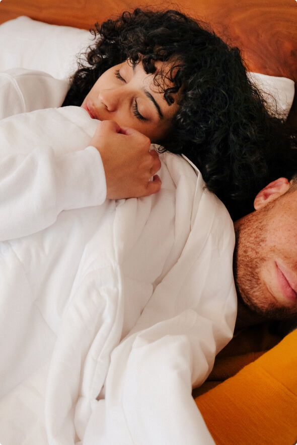 A man and woman lying in bed with the award winning Slumber Cloud Lightweight Comforter