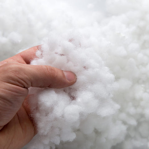 A man holding fiber filling treated with Outlast Technology to regulate temperature.