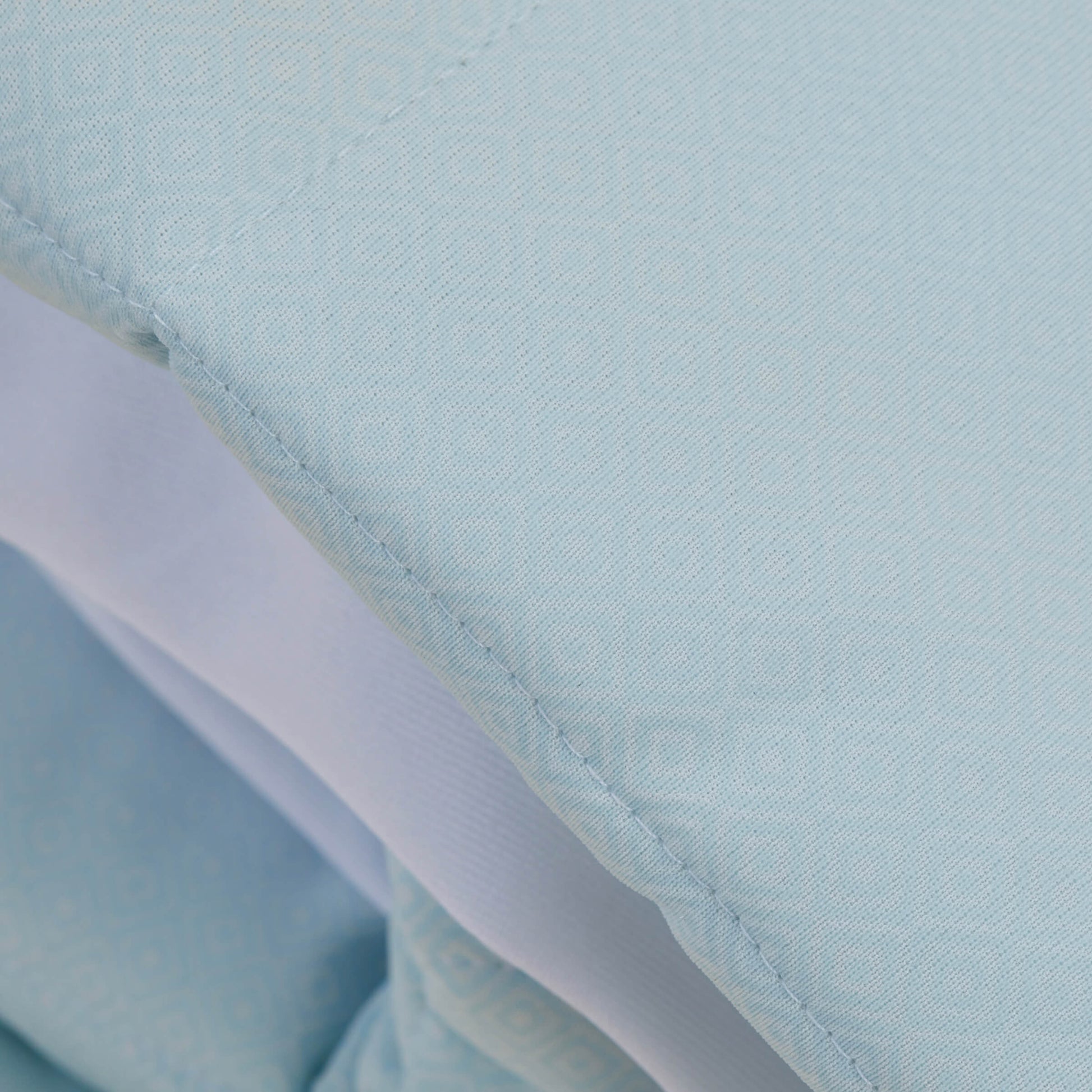 A close up shot of the Slumber Cloud Essential Mattress Pad made with Outlast temperature regulation technology.
