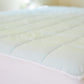 A close up shot of the Slumber Cloud Essential Mattress Pad made with Outlast temperature regulation technology.