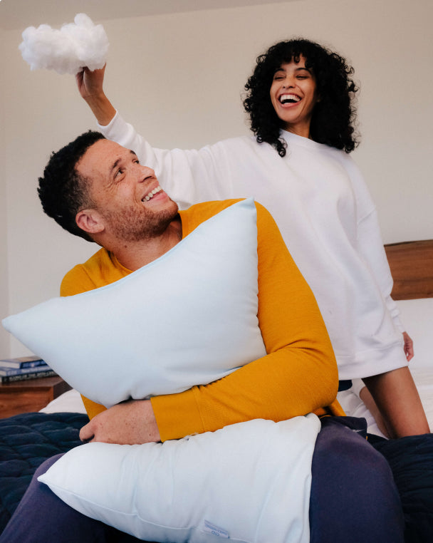 A man and woman playing with the foam filling from the award winning Slumber Cloud UltraCool Pillow