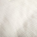 A detailed view of the fabric on the Avec cotton quilt in pearl