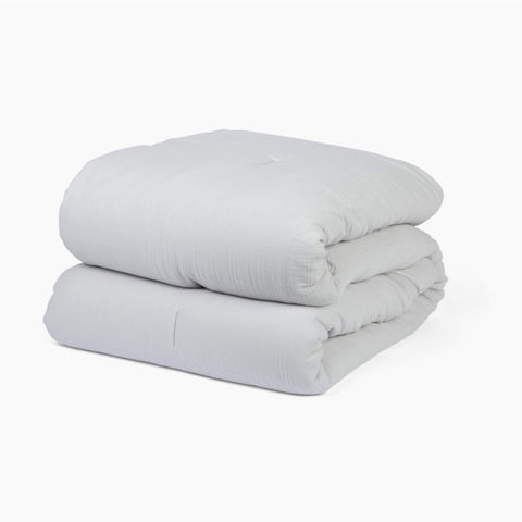 Avec cotton quilt in mist folded neatly on a white background