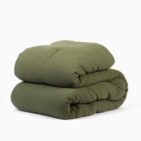 Avec cotton quilt in moss folded neatly on a white background