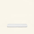 A folded Slumber Cloud Core Mattress Protector - Crib on a cream background