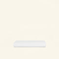 A folded Slumber Cloud Essential Fitted Sheet - Crib on a cream background
