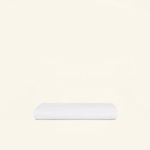 A folded Slumber Cloud Essential Fitted Sheet - Crib on a cream background