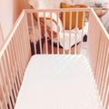 A top view of a crib with a Slumber Cloud Essential Fitted Sheet - Crib