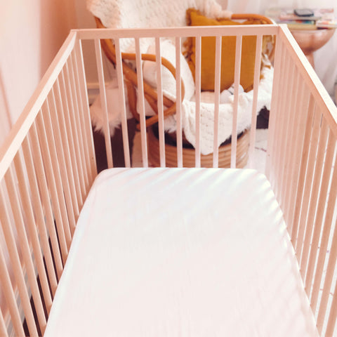 A top view of a crib with a Slumber Cloud Essential Fitted Sheet - Crib