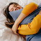 Woman smiling and squeezing a pillow with the Slumber Cloud Essential Pillowcases with temperature regulation technology