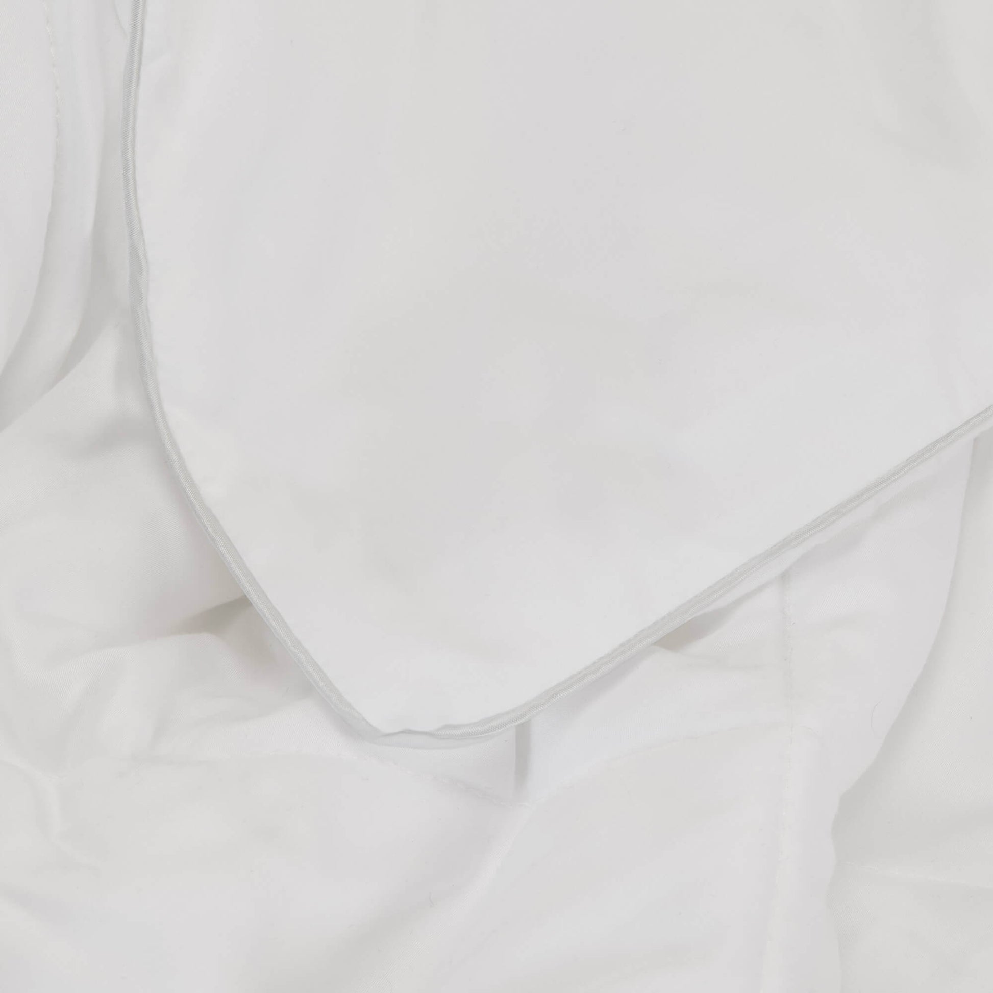 Detailed view of the piping on the Slumber Cloud UltraCool Comforter takes the ClimaDry™ by Outlast and pairs it with an 89% cooling nylon and 11% spandex outer cover that mimics silk creating the silky smooth and soft to the touch hand feel.