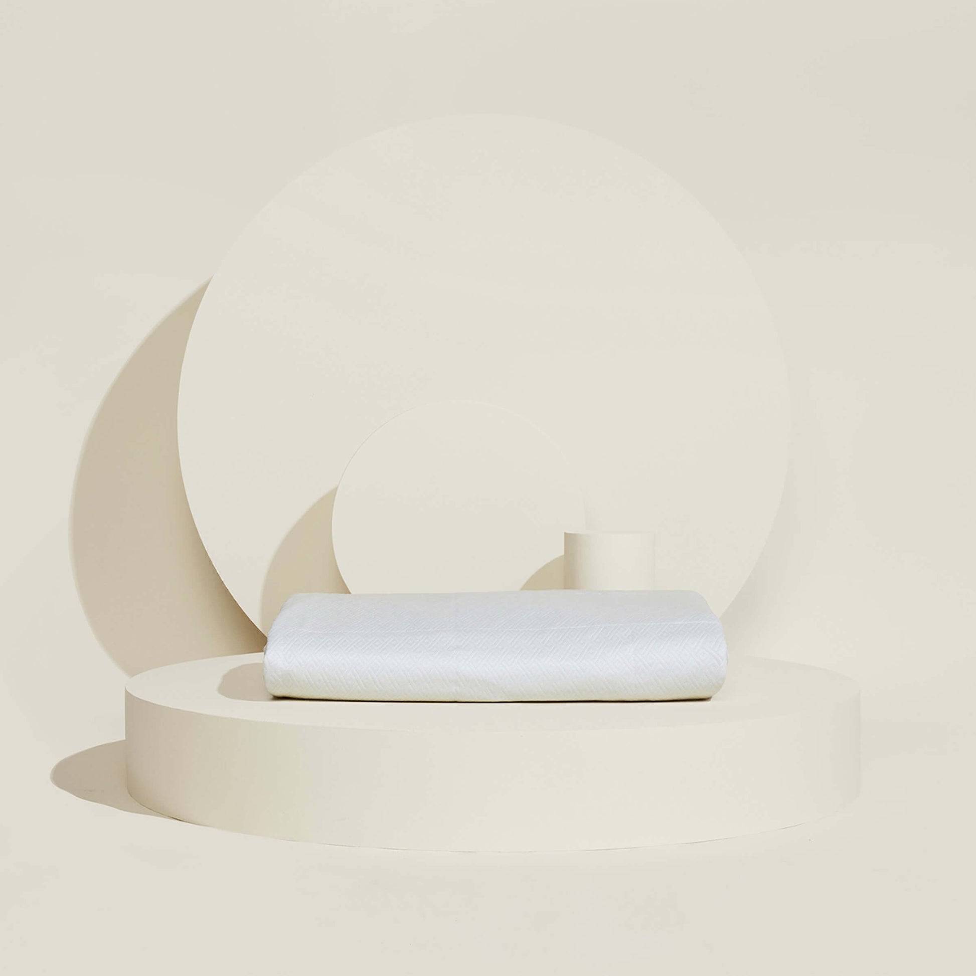 The temperature regulating Core Mattress Protector from Slumber Cloud folded on a propped background