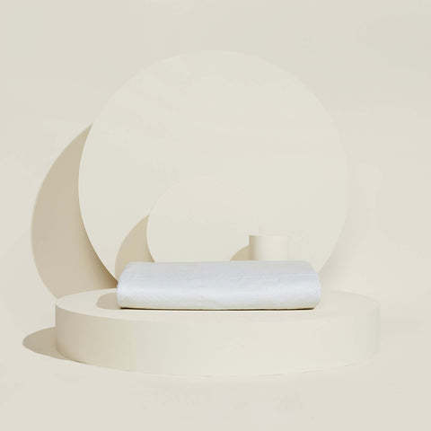 The temperature regulating Core Mattress Protector from Slumber Cloud folded on a propped background