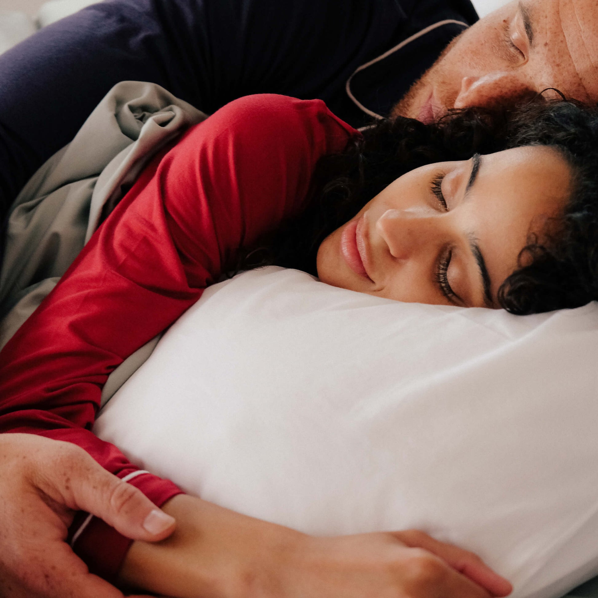 A couple sleeping while using a Slumber Cloud Core Pillow Cover with temperature regulation technology