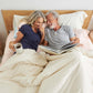A couple lying in bed with the Slumber Cloud Down Comforter made with temperature regulation technology
