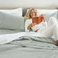 Woman lying in bed reading with the Slumber Cloud Essential Duvet Cover with temperature regulation technology