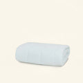 The Slumber Cloud Essential Mattress Pad made with Outlast temperature regulation technology, folded on a cream background