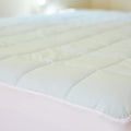 A close up shot of the Slumber Cloud Essential Mattress Pad made with Outlast temperature regulation technology.