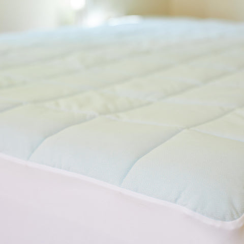 A close up shot of the Slumber Cloud Essential Mattress Pad made with Outlast temperature regulation technology.