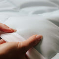 A close up shot of the Slumber Cloud Essential Mattress Pad made with Outlast temperature regulation technology.