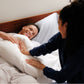 Couple lying in bed with the Slumber Cloud Essential Pillowcase with temperature regulation technology