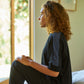 Woman wearing the Slumber Cloud Essential Raglan Pullover made with Outlast temperature regulation technology
