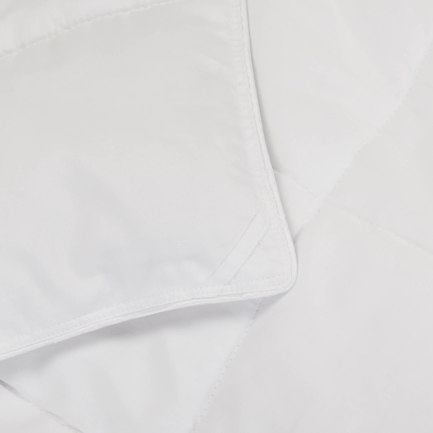 Detailed view of the corner loops on the Slumber Cloud Lightweight Comforter made with Outlast temperature regulation technology to help you stay cool through the night. | Cooling Technology