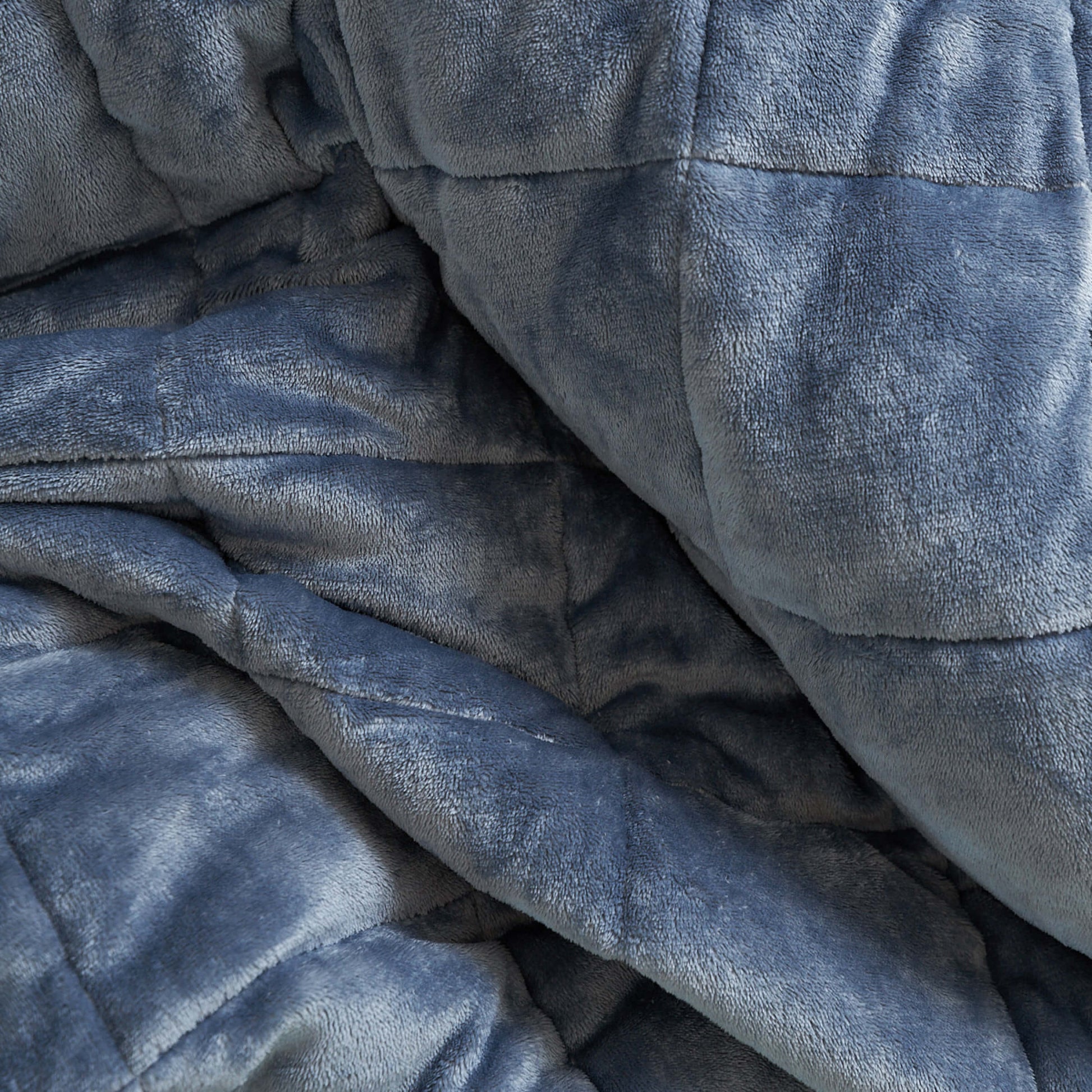 Detailed view of the Slumber Cloud Plush Throw Blanket made with Outlast Temperature regulation technology in bold blue
